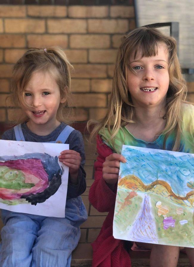 Two sisters in the garden with their paintings